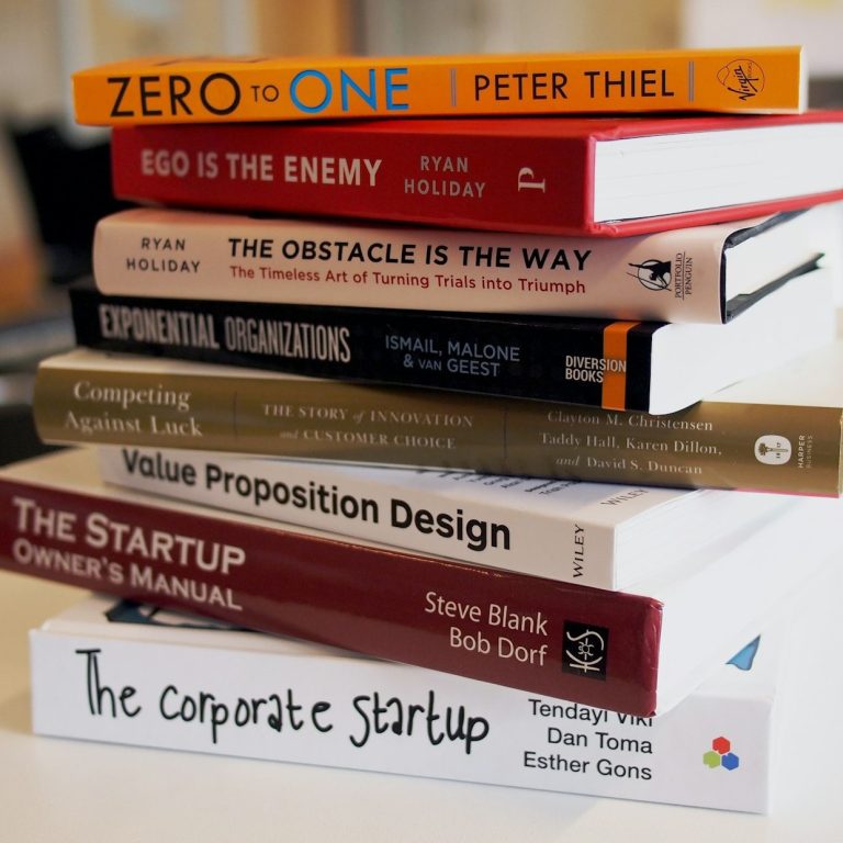 Eine Stapel von neun Büchern über Unternehmertum und Geschäftsstrategie.