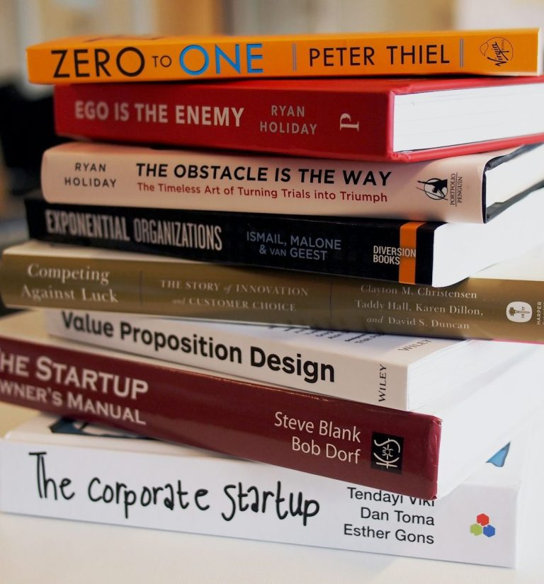 Eine Stapel von neun Büchern über Unternehmertum und Geschäftsstrategie.